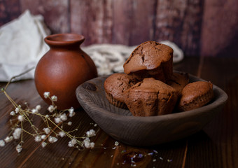 four chocolate cupcakes in a wooden ethnic plate