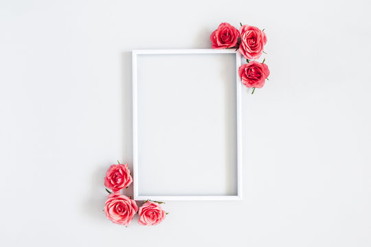 Flowers composition. Rose flowers, photo frame on pastel gray background. Flat lay, top view, copy space
