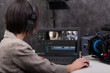 Young woman video editor working in studio