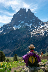 Fototapeta na wymiar hiker woman resting and looking the Pic du Midi Ossau in the french Pyrenees mountains