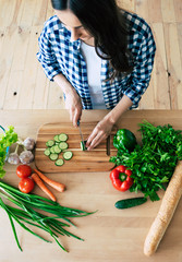 Female hands cutting vegetables in the kitchen. Woman cooking healthy food. Fresh vegetables on the...