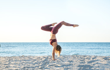 caucasian healthy adult woman with beautiful body doing yoga at sunrise on the beach, yoga poses