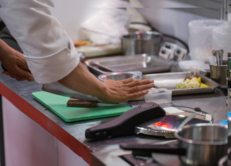 Chef cutting food in a plastic cutting board. Homemade cooking food