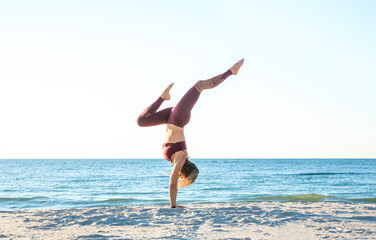 Fototapeta na wymiar caucasian healthy adult woman with beautiful body doing yoga at sunrise on the beach, yoga poses