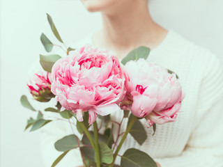 Girl holds beautiful bouquet pink from peonies. The concept of celebration and love.