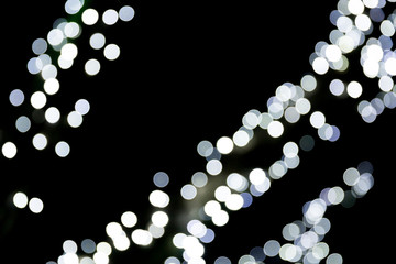 Unfocused abstract white bokeh on black background. defocused and blurred many round light