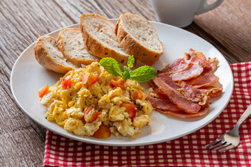 Scrambled egg with tomato sliced, bacon grill and breads, Homemade Breakfast.