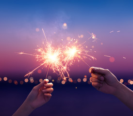 Couple holding a sparklers on the beach