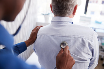 Senior Male Patient Having Medical Exam With Doctor In Office