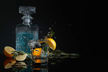 Gin-tonic with lemon slices and twigs of rosemary.