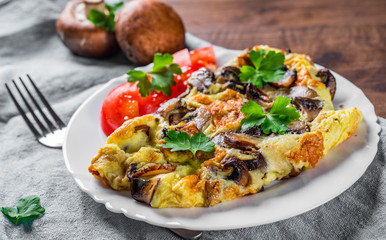 omelette with mushrooms in white plate on wooden table background