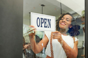 Pretty young Black woman opening her store in the morning