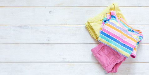 Marie Kondo tyding up method concept - folded kids clothes in pastel colors, copy space