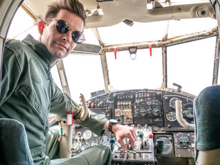 A handsome young pilot sitting in the cockpit