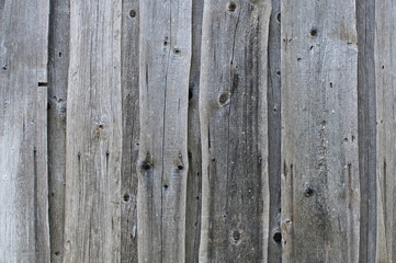 Textured background of old grey faded boards covered with cracks