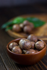 Macadamia nuts in a brown ceramic bowl.