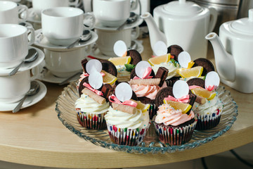Tasty cupcakes on a crystal dish with empty white signs.