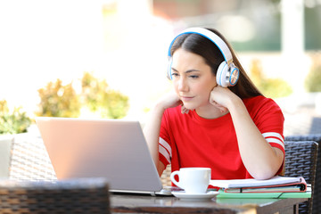 Studious student e-learning watching tutorials on laptop