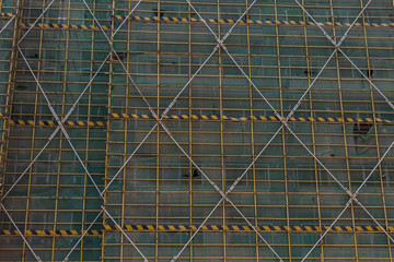 Protective fence and steel frame pattern on the exterior of the construction building