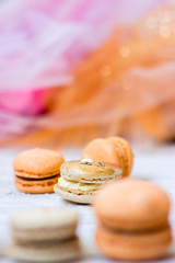 Orange macaroons with chocolate filling and Easter bunny macaroons, on orange tulle background
