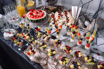 Fruit salad in cups, beautifully decorated table.