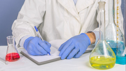 Lab technician writes the results of successful research into the notebook