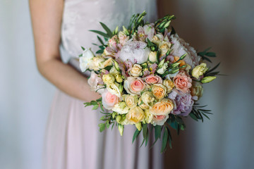 Bouquet in the hands of the bride, peonies and roses.