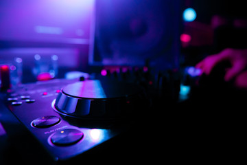 Obraz na płótnie Canvas DJ mixing tracks on a mixer in a nightclub
