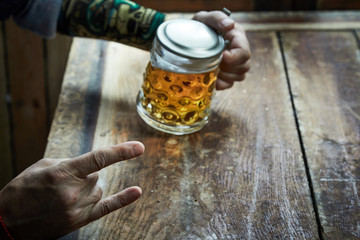 Man drinking beer giving a Devil Horns gesture