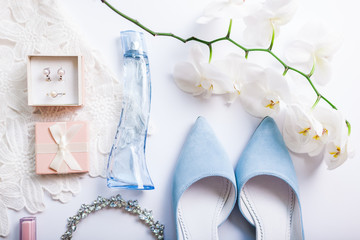 Stylish female wedding clothes, blue shoes and accessories with flowers. Morning of bride