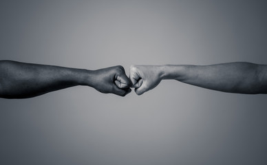 Fist of different skin colors giving fist bump. Conceptual image of race tolerance and stop racism