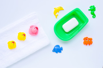 Pink and yellow duck  toys on white towel with  soap  and sea animals on white background.