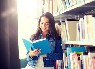 education, high school, university, learning and people concept - smiling student girl reading book at library