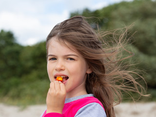 Fototapeta premium little cute girl eating rosehip