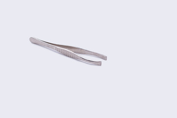 Metal tweezers isolated on white background. Eyebrow tweezers, copy space.