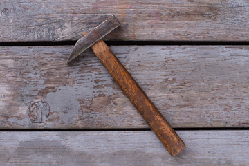 Hammer with wooden handle. Old tool on wooden boards. Vintage style.