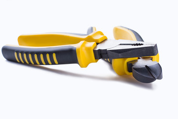 Crossed pliers on white background. Two pliers with black and yellow handle. Flat lay composition.