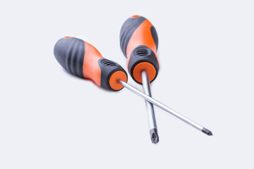 Two crossed screwdrivers isolated on white background. Repair tools with rubber handle.