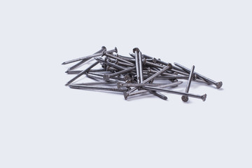 Heap of metal nails on white background. Pile of iron nails. Construction tools concept.