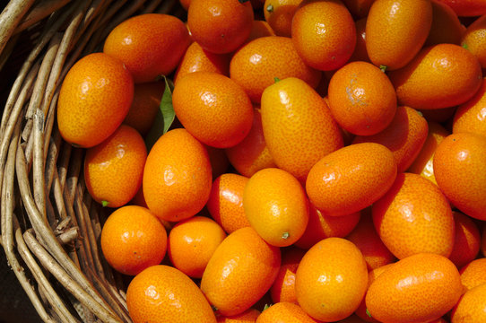 Fresh juicy oranges in a basket in the market. Orange background of fresh oranges. Closeup