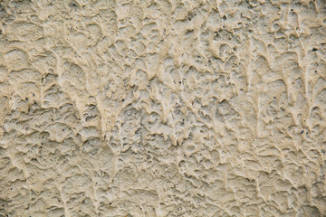 Texture of concrete and plaster on the wall. Drips on the wall close-up. Wavy lines in the plaster. Three-dimensional texture, background.