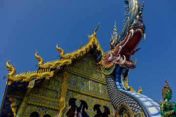 Fototapeta na wymiar Dragon head sculpture and facade of the Blue Temple in Chiang Rai, Thailand