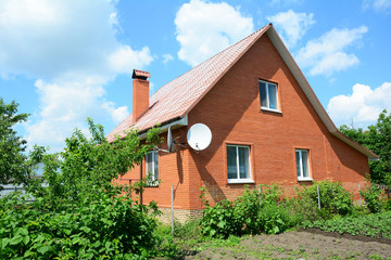 Cozy brick house with antenna and metal roof