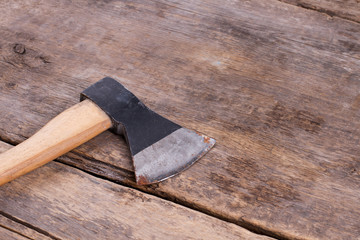 Rusty axe on old wooden floor. Tool on wooden background with copy space.