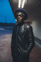 portrait of young black man standing in the street and looking camera