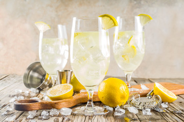 Trendy summer cold drink. St Germain French Spritz cocktail with lemon slices, old rustic wooden...