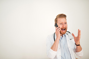 Angry doctor yelling while talking over mobile phone, copy space.