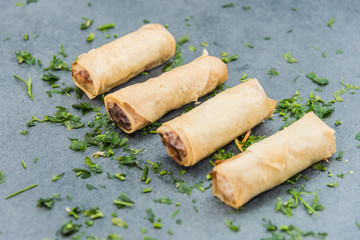 Fried spring rolls surrounded by ingredients. Buffet of Assorted of Chinese Food Dishes.