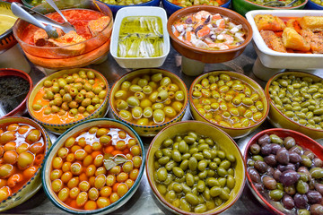 Marinated olives with herbs in a market.