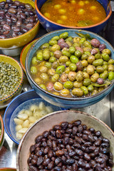 Marinated olives with herbs in a market.